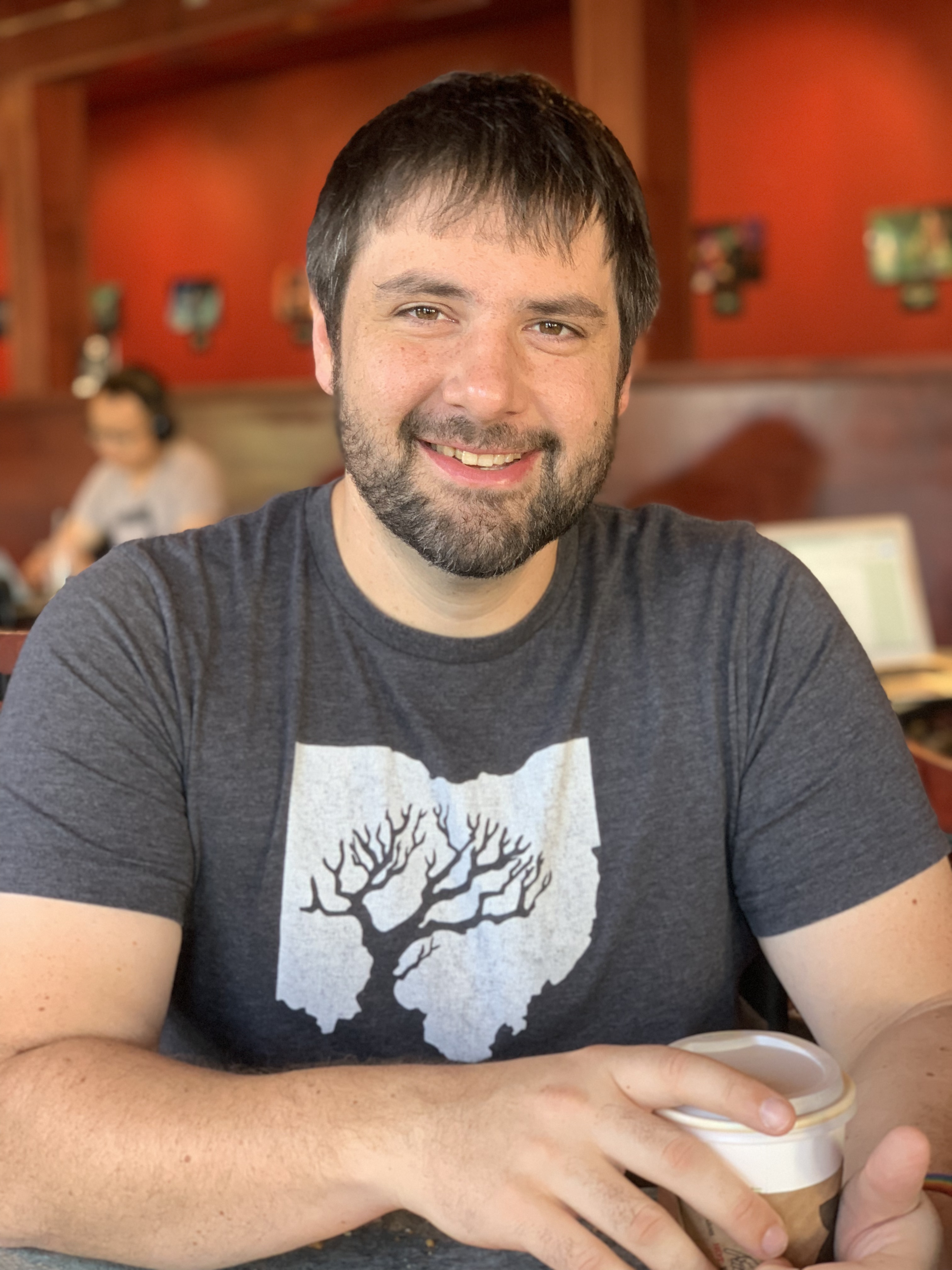 Photo of A.M. Knight smiling at the camera in Red Rock coffee shop in Mountain View, California in 2018